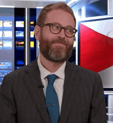 a man with a beard wearing glasses and a suit and tie