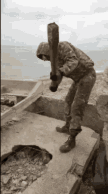 a man in a camouflage uniform is holding a baseball bat