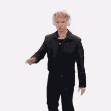 a man wearing headphones and a black jacket is waving