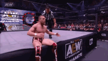 a man in a wrestling ring with a banner that says all elite wrestling on it