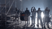 a group of people are playing drums on a stage .