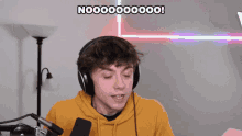 a young man wearing headphones and a yellow hoodie says nooooo000000