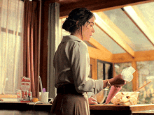 a woman in a kitchen with a carton of milk on the counter