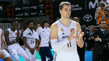 a basketball player with the number 11 on his jersey stands in front of his teammates
