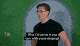 a man with glasses and a black shirt is talking about what if it comes in your room while you 're sleeping