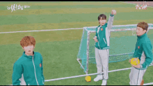 two boys are playing soccer on a field and one of them is holding a yellow ball .