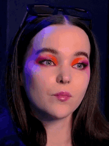 a close up of a woman 's face with orange eyeshadow