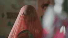 a close up of a woman 's face covered in a pink cloth