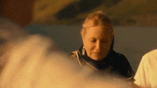 a woman is standing in front of a fire and smoke coming out of it .