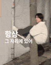 a person sitting on a pole with korean writing on the bottom