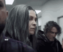 a man and a woman are standing next to each other in a hallway .