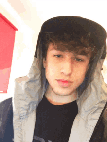 a young man wearing a black hat and a jacket with the letter a on it