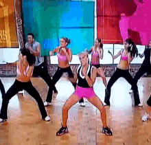 a group of women are dancing together in a gym