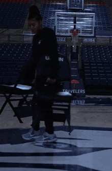 a person standing on a basketball court with a travelers logo on the floor