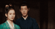 a man and a woman are standing next to each other .