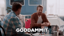 two men are sitting at a table and one of them is saying goddamnit .