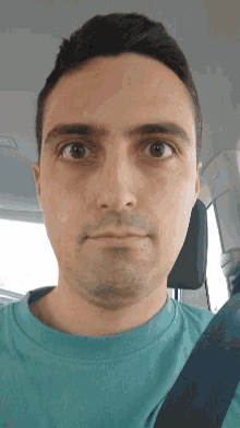 a close up of a man 's face with a blue shirt