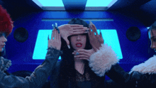 a woman covering her eyes with her hands in front of a speaker