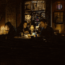 a man and a woman sit at a table with a lamp