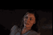 a woman with wet hair is making a funny face in a dark room