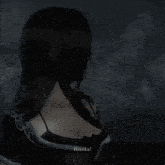 the back of a woman 's head is shown in a dark room