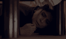a woman is laying under a table in a dark room and smiling .