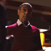 a man in a red sweater holds a piece of paper in his hand