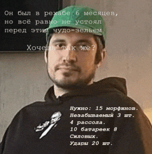 a man wearing a green hat and a black hoodie with russian writing