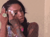 a woman with a ring on her finger is crying while holding a tissue to her face .