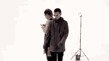 a man and a woman are standing next to each other in a white room .