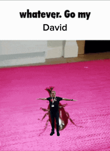 a man with his arms outstretched is standing in front of a pink background with the words whatever go my david