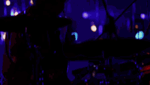 a blurred image of a person in a dark room with a light behind them