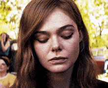a close up of a woman 's face with a serious look on her face