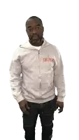 a man wearing a grey sweatshirt with the word jesus on it is smiling