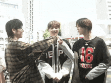 a man wearing a celine t-shirt shakes hands with two other men