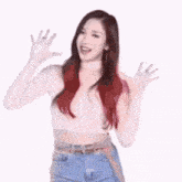 a woman with long red hair is holding a gun over her head .