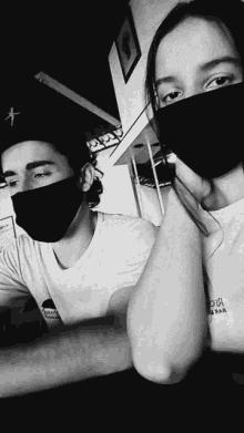 a black and white photo of a man and a girl wearing face masks