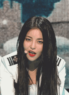 a close up of a woman wearing a white jacket with a microphone