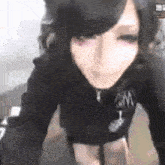 a woman in a black hoodie is taking a selfie with her camera .