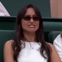 a woman wearing sunglasses is making a funny face .