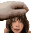 a hand is holding a woman 's head in a pixelated image .