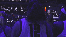 a person wearing a purple jersey with the number 12 on it