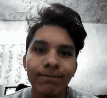 a close up of a young man 's face with a slight smile on his face .