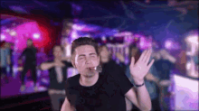 a man in a black shirt is smoking a cigarette at a party