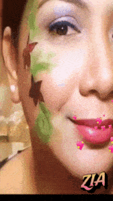 a close up of a woman 's face with flowers painted on it and the name zia on the bottom