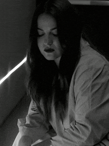 a black and white photo of a woman in a white shirt