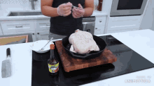 a man is cooking a chicken in a skillet with a bottle of knorr sauce on a cutting board