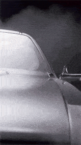 a silver car with smoke coming out of the hood