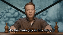 a man is sitting at a table with the words as the main guy in this thing