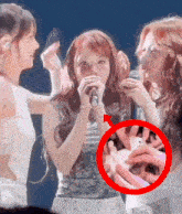 a woman singing into a microphone with a red circle around it